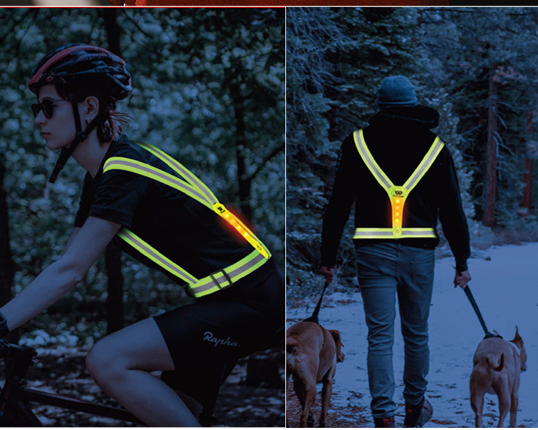 Reflective safety vests worn by a cyclist and a person walking dogs in a forest setting.